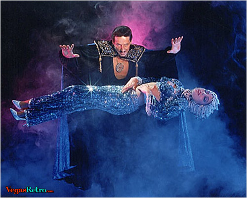 Photo of magician Barclay Shaw levitating a showgirl