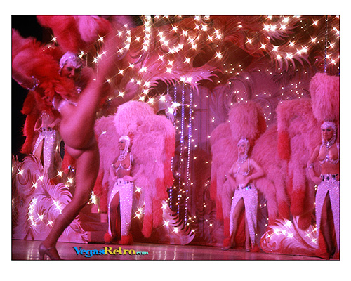 Image of Las Vegas Showgirls in pink feathers and a high kicking dancer